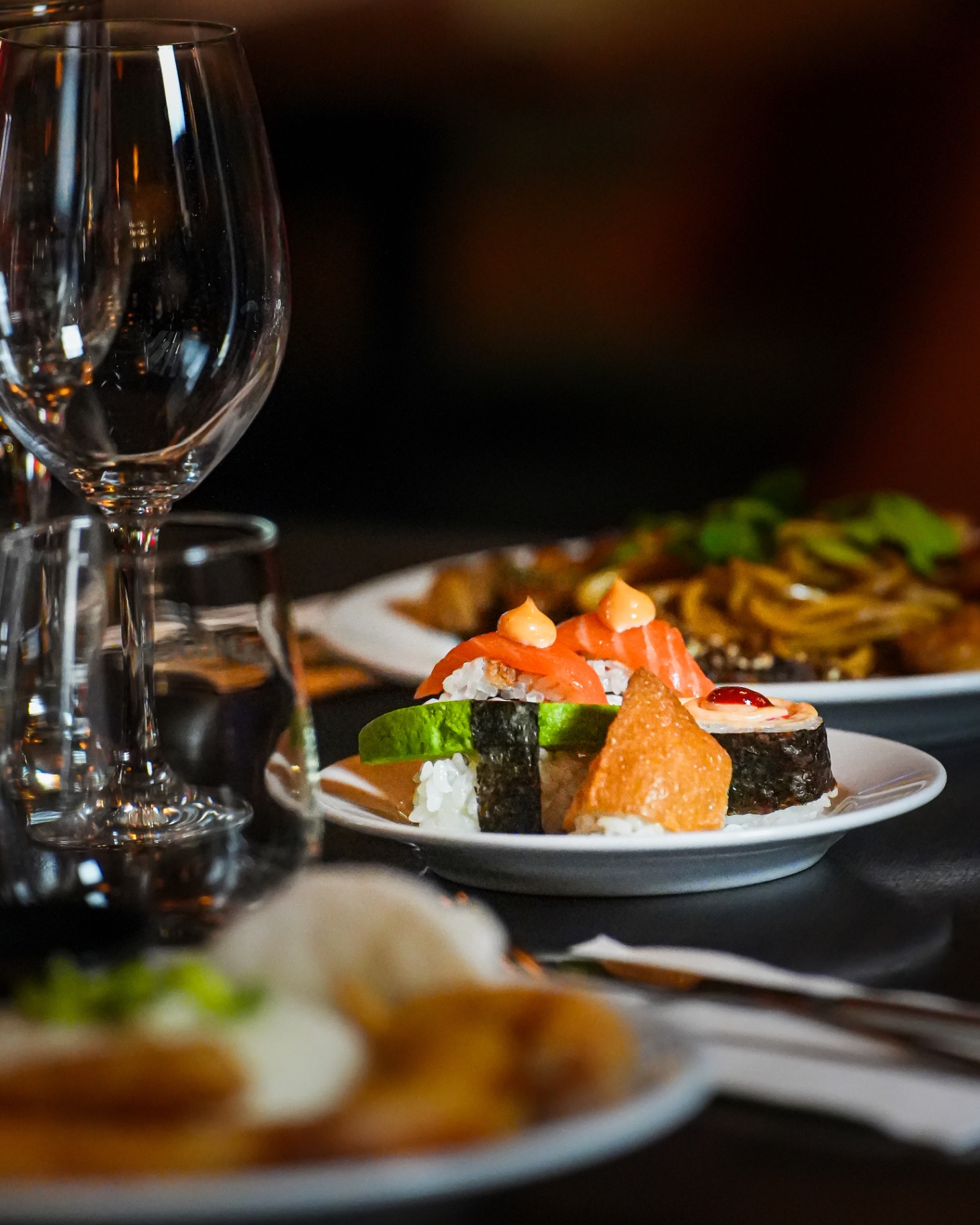 Plated sushi with wine glasses